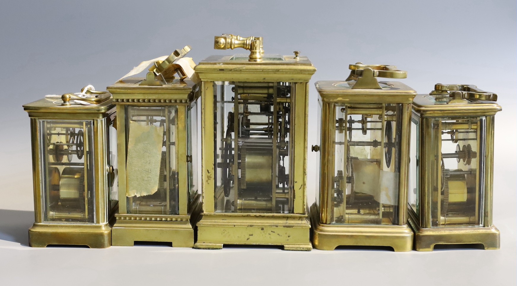 Five early 20th century and later lacquered brass carriage clocks and timepieces, in varying states of repair